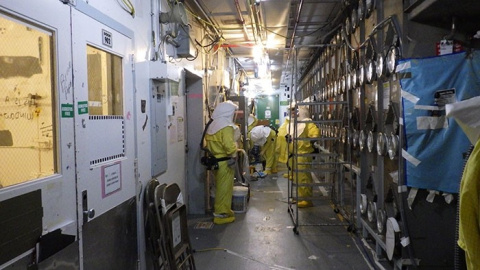Workers applied a fixative to lock down contamination before beginning demolition of the Plutonium Reclamation Facility canyon.