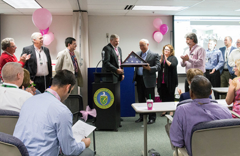 Ben Harp, Office of River Protection (ORP) Deputy Manager (center) and the rest of ORP senior leadership team present retiring ORP Manager Kevin Smith (center right) with the flag that flew over the ORP building during his tenure as ORP manager.