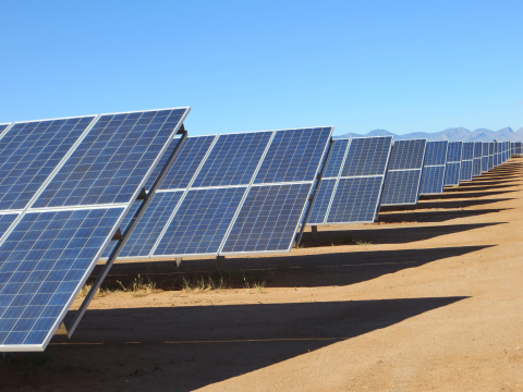 A long row of PV panels in the desert.