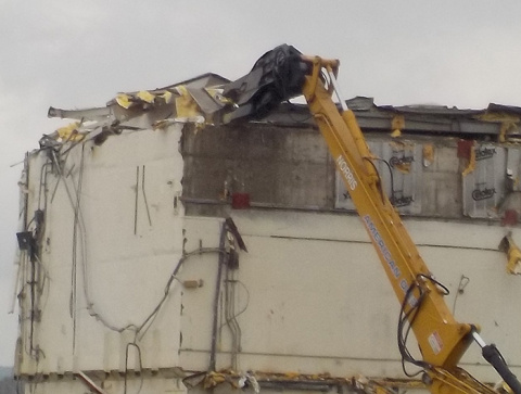 Workers tear down portions of the Vitrification Facility with the least radiological contamination in the first phase of demolition. Roof coming off.