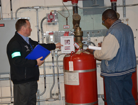 Eric Bell (left) of Operations Support observes Facility Operator Charles Ray during a scenario-based training drill.