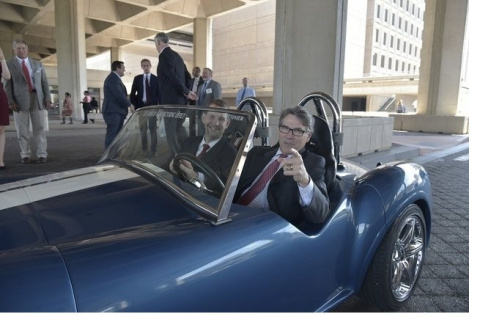 Two men sitting inside a 3D printed Shelby Cobra sports car
