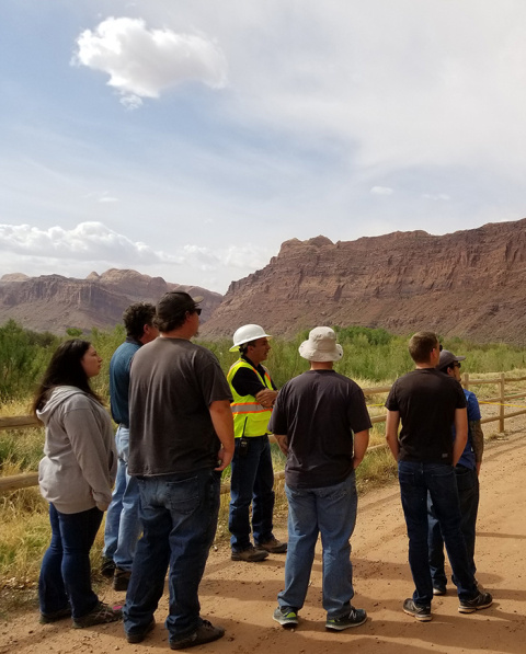 Senior Program Manager Joe Ritchey, center, explains Moab Site revegetation work to students visiting from the University of Utah.
