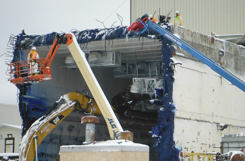 Crews lower a cooler to the floor as part of Vitrification Facility demolition activities.