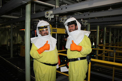 Shay DeWitt, nuclear chemical operator, left, and Mike Garza, field work supervisor, give a thumbs-up during the first day of sludge retrieval on June 12.