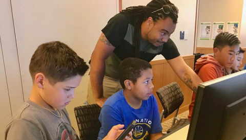Volunteer Eugene Boykin answers student questions during the Cyber Defense challenge.