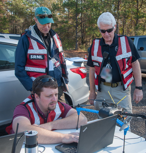 From left, Drew Morgan and Kevin Kochersberger of Virginia Tech, and Todd Coleman of Savannah River National Laboratory prepare a test flight to demonstrate how unmanned aircraft support EM’s cleanup mission.