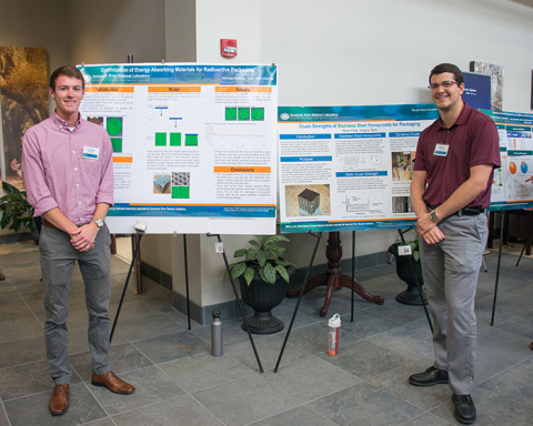 Seniors Nicholas Manning, Texas A&M, and Kevin Frew, Virginia Tech, stand with their posters at the Savannah River National Laboratory Intern Poster Session, presenting their findings and work completed this summer.