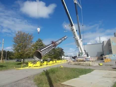 A crane moves the ventilation stack to a horizontal position.