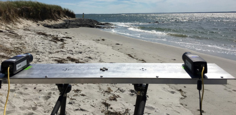 Photo of a table set up on a beach with two cameras on it.