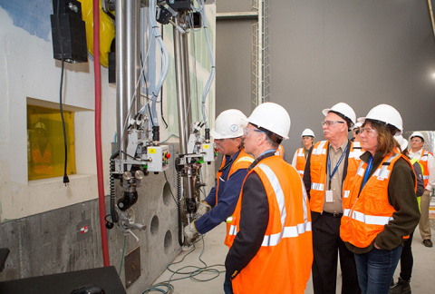 Equipment operator, Dwight Bowman, demonstrates a manipulator moving objects in the mock-up of a 324 Building hot cell for DOE Chief Financial Officer John Vonglis, Richland Operations Office Manager Doug Shoop, and EM Assistant Secretary Anne White.