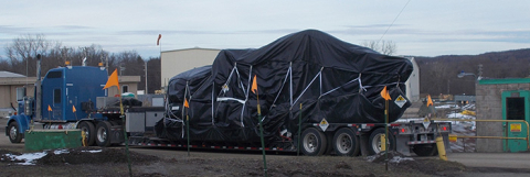 A truck delivers an excavator to the West Valley Demonstration Project for EM’s use in demolition activities.