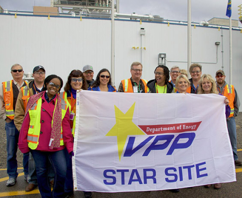Fluor Idaho employees hold up their DOE Voluntary Protection Program flag.