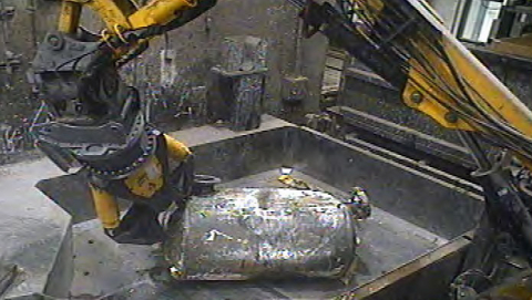 Operators use a robotic arm to size a tank at the Advanced Mixed Waste Treatment Project.
