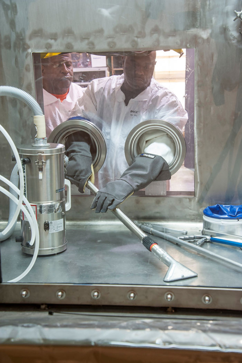 SRNS risk reduction operators Antonio Jenkins, left, and Sylvester Palmer, practice using a tool in a mock-up facility for eventual use in Building 235-F.