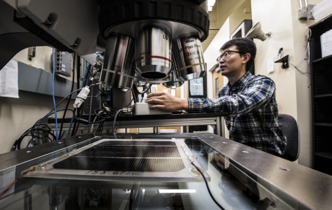 Tao Song, a researcher  from the Cell Performance and Measuring group at NREL,  takes area measurements in his lab.