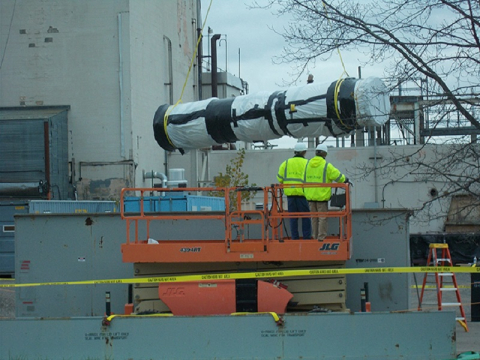 CH2M HILL BWXT West Valley workers remove a 900-pound section of the ventilation exhaust cell duct from the roof of the Main Plant Process Building in November 2018.