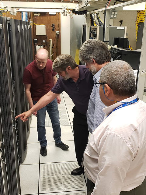 Mike Cline, second from left, project director for soil and groundwater cleanup with EM's Richland Operations Office (RL), points out the new modeling system during a tour with RL and contractor managers. 