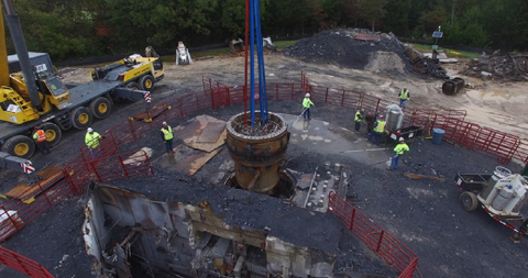 Workers remove the Southwest Experimental Fast Oxide Reactor from its container as part of the decommissioning project. 