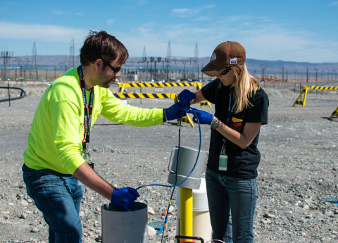 Freestone Environmental Services geologists Zack McGuire, left, and Lindsey Getchell deploy a sensor the firm developed under the Small Business Innovation Research Program.