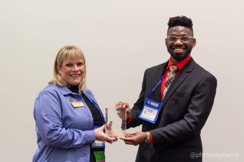 Michael Benjamin, a Washington River Protection Solutions chemical engineer at the Hanford Site, is recognized with an award at the 45th National Society of Black Engineers convention by Mikala Windham, chair of the society’s local chapter.
