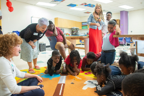 Savannah River Nuclear Solutions employees Kim Mitchell, far left, and Francine Burroughs, second from left, demonstrate how the bess beetle's uniquely clawed feet provide traction and allow the insect to pull more than its own body weight in paper clips.
