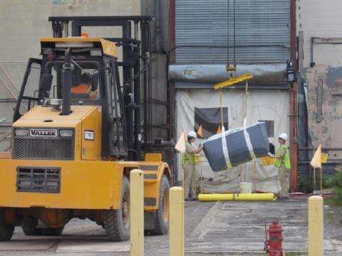 Workers remove a 900-pound lift bag of asbestos material from the Main Plant Process Building at EM’s West Valley Demonstration Project. The bag was carried out of the facility on a conveyor system created by employees at the site.