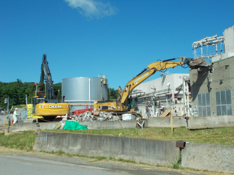 Workers begin demolishing a former utility room extension building at EM’s West Valley Demonstration Project. It was one of seven support buildings of the Main Plant Process Building. Three of those structures remain and are scheduled for demolition.