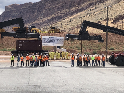 EM Moab Uranium Mill Tailings Remedial Action Project employees gather around project equipment after loading the 10 millionth ton of uranium mill tailings into a container to be shipped by train to the Crescent Junction disposal cell. 