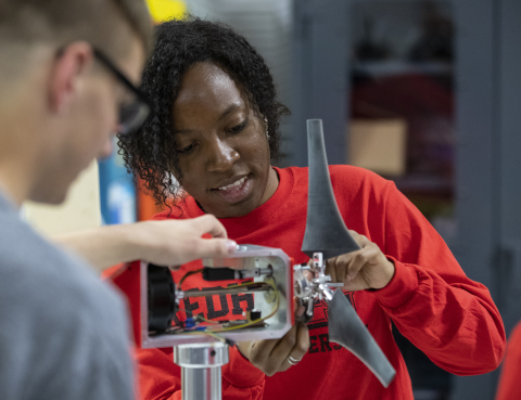 Students inspect a small wind turbine designed and built for the DOE Collegiate Wind Competition.