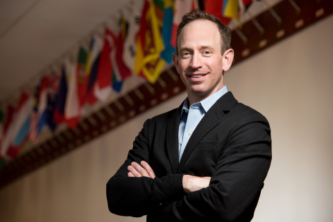Director Douglas Mans stands in front of EMSL’s wall of flags representing its staff and users from around the world. 