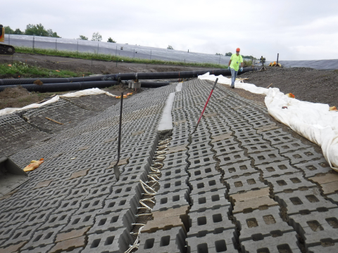 An employee walks near a new erosion control measure installed on the north slope of an inactive disposal area at EM’s West Valley Demonstration Project Site.