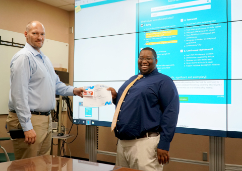 Savannah River Remediation (SRR) Process Applications Engineer Eric Dantzler, right, receives a gift card from his co-worker Jason Hargrave. Dantzler was nominated for the reward through SRR’s new RAVE (Recognizing Achievement of Values and Expectations) 