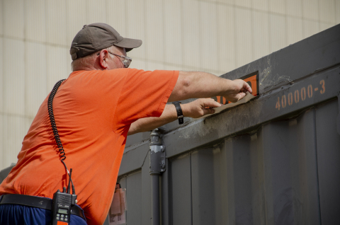 Damon Cates applies labels on a shipping container in preparation for the first cold trap leaving the EM Paducah Site.