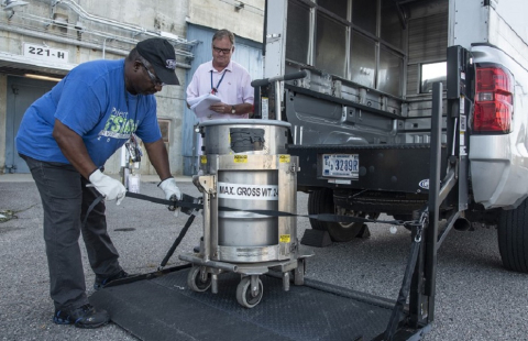 HB Line operators Tony Jacobs, left, and Tom Carraway load a sample drum for shipment to Savannah River National Laboratory. 