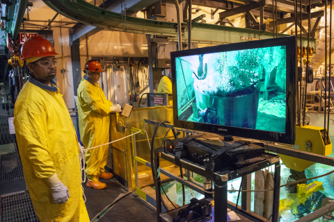 Savannah River Nuclear Solutions employees Erik Tucker, left, and Randy Fanning watch as the inner lid of a High Flux Isotope Reactor (HFIR) spent nuclear fuel shipping cask is removed under water in the L Area disassembly basin.