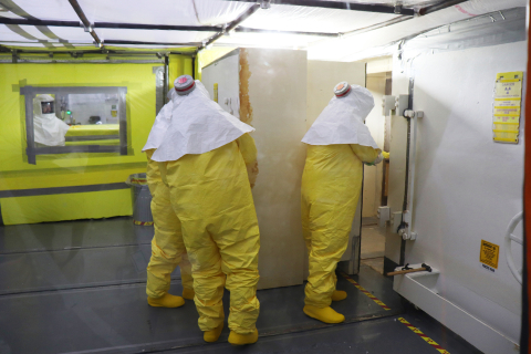 Personnel open a 36,000-pound concrete door to enter a hot cell within Building 2026 at Oak Ridge.