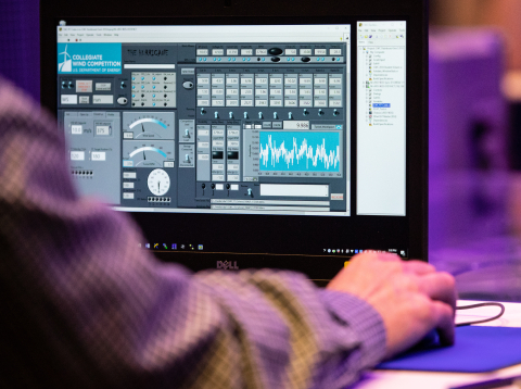 Person sits using a mouse at a computer during the CWC competition.