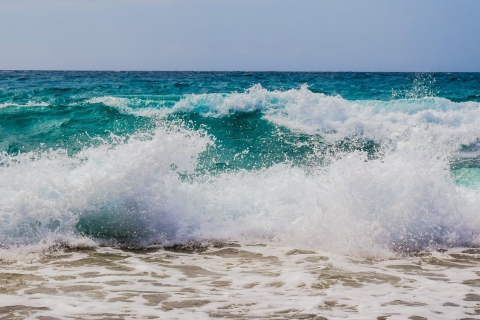 Ocean waves hitting a beach shore.