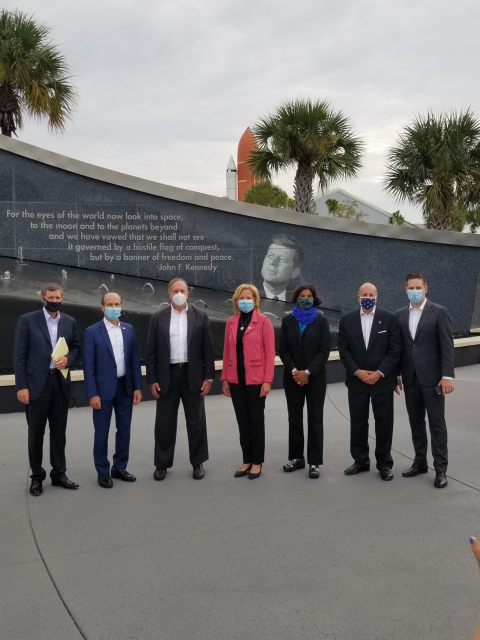 Energy leaders stand in front of Cape Canaveral.