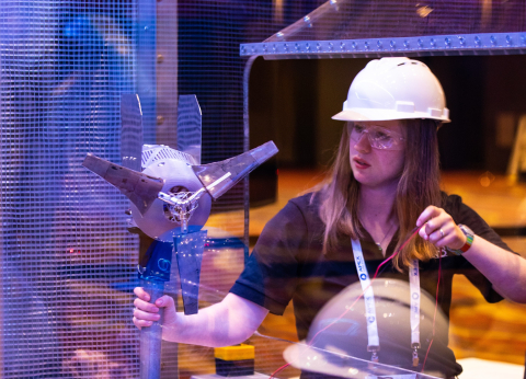 Woman holding parts of a wind turbine.