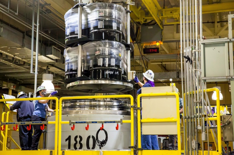 Waste handlers take radiological readings as a crane lifts containers from a TRUPACT-II cask in the contact-handled waste bay at the Waste Isolation Pilot Plant. The DOE facility has resumed accepting shipments and processing waste after a two-month annual maintenance outage.