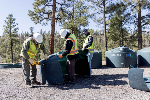 Workers with Newport News Nuclear BWXT Los Alamos cut up plastic storage tanks for recycling at the Los Alamos Eco Station. The tanks had been used to support groundwater monitoring activities at Los Alamos National Laboratory and have since expired.