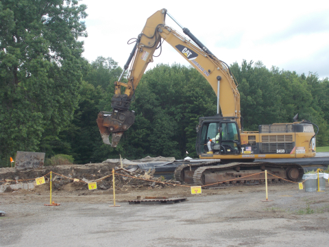 Workers use an excavator to remove soil that had been excavated for the installation of a unique groundwater treatment system at the West Valley Demonstration Project years ago. The soil and a structure used to store the soil will be shipped offsite by rail this month.