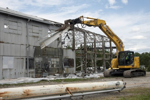 Workers demolish a section of the metal roof over the Ford Building at the Savannah River Site. At the height of the Cold War, the facility was used to test components used in five nuclear reactors at the site.