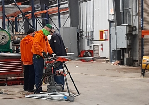 From left, electricians Chris Peck, Chris Bottoms, and Greg Cash work on modifications to relocate personnel and operations from 129,800 square feet of space in the C-720 Maintenance and Storage Building into a smaller facility.