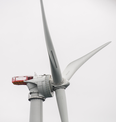 A close-up of the turbine blades and nacelle of one of the offshore wind turbines in Block Island, Rhode Island, against a gray and cloudy sky.