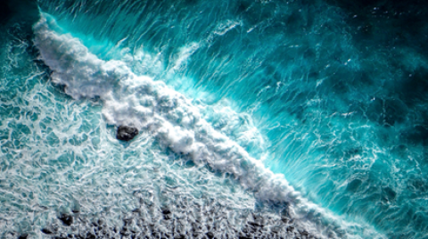 Ocean waves crash against rocks.