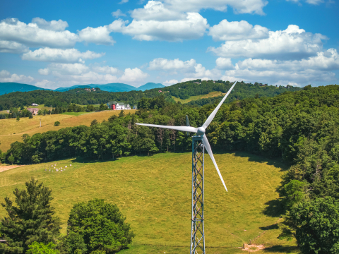 Distributed wind turbine with mountains in the background.