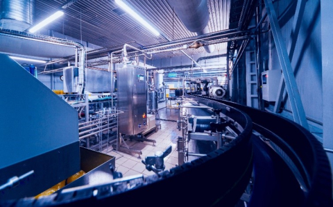 A photo inside a manufacturing facility with a long conveyer belt. 